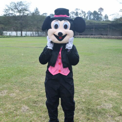 Pink Mickey is a Mascot With a bright pink outfit, big smile, and playful energy