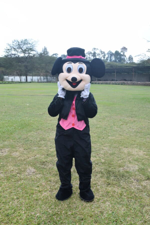 Pink Mickey is a Mascot With a bright pink outfit, big smile, and playful energy